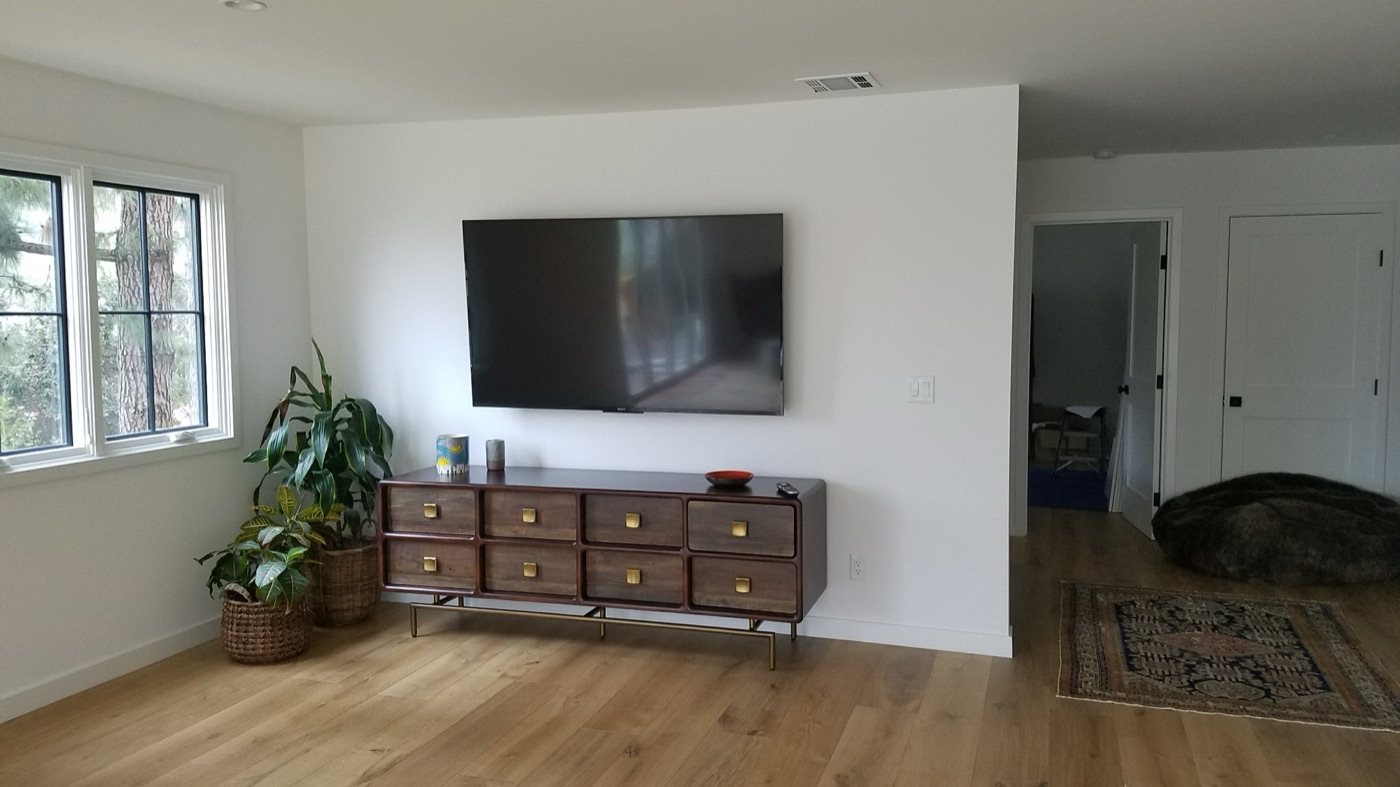 TV mounted above a wood credenza in a bright modern Centennial Hills living room